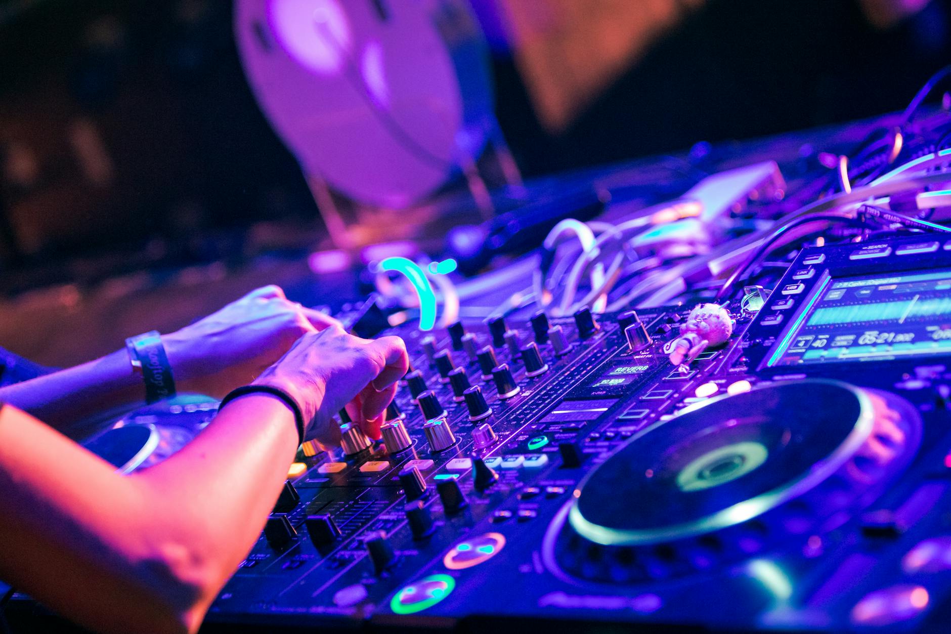 DJ adjusting the controls on a mixer
